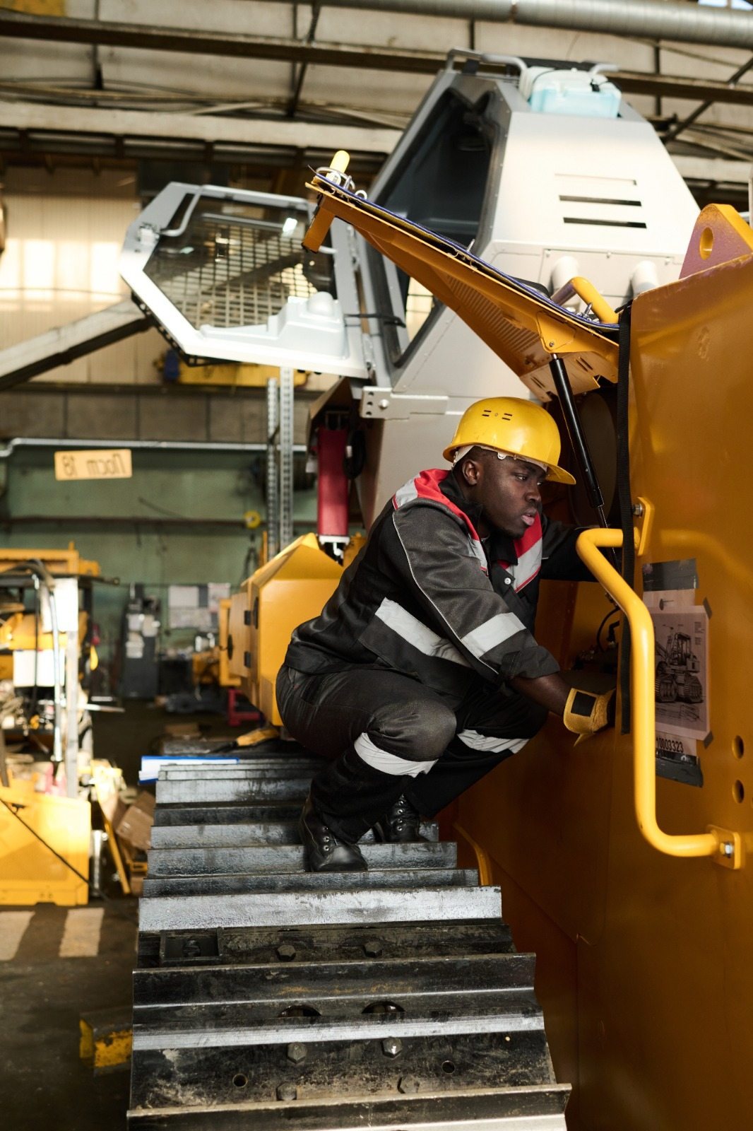 Technician servicing a yellow earthmoving machine